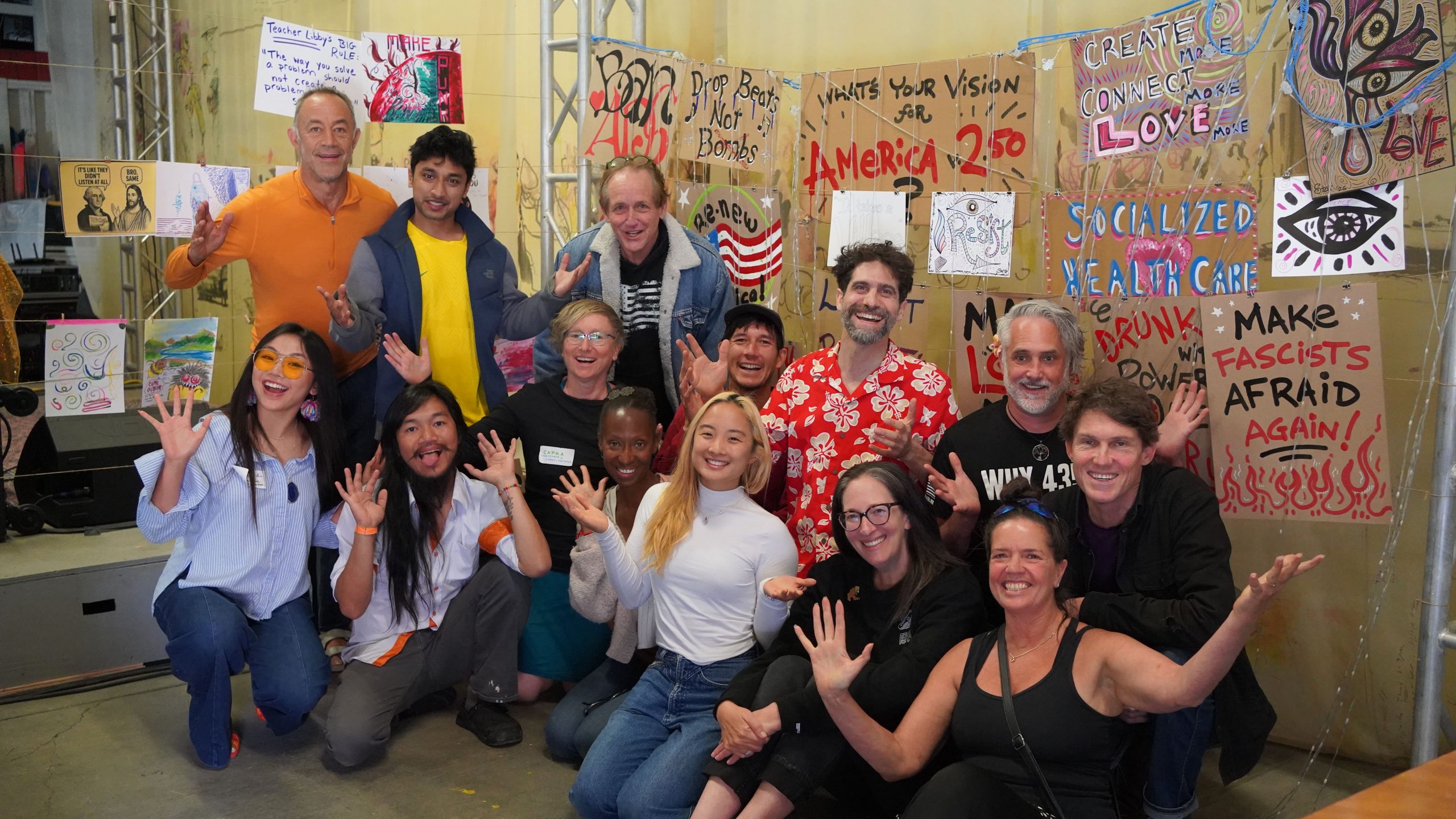 A crowd of people gathered in front of a wall of handmade posters