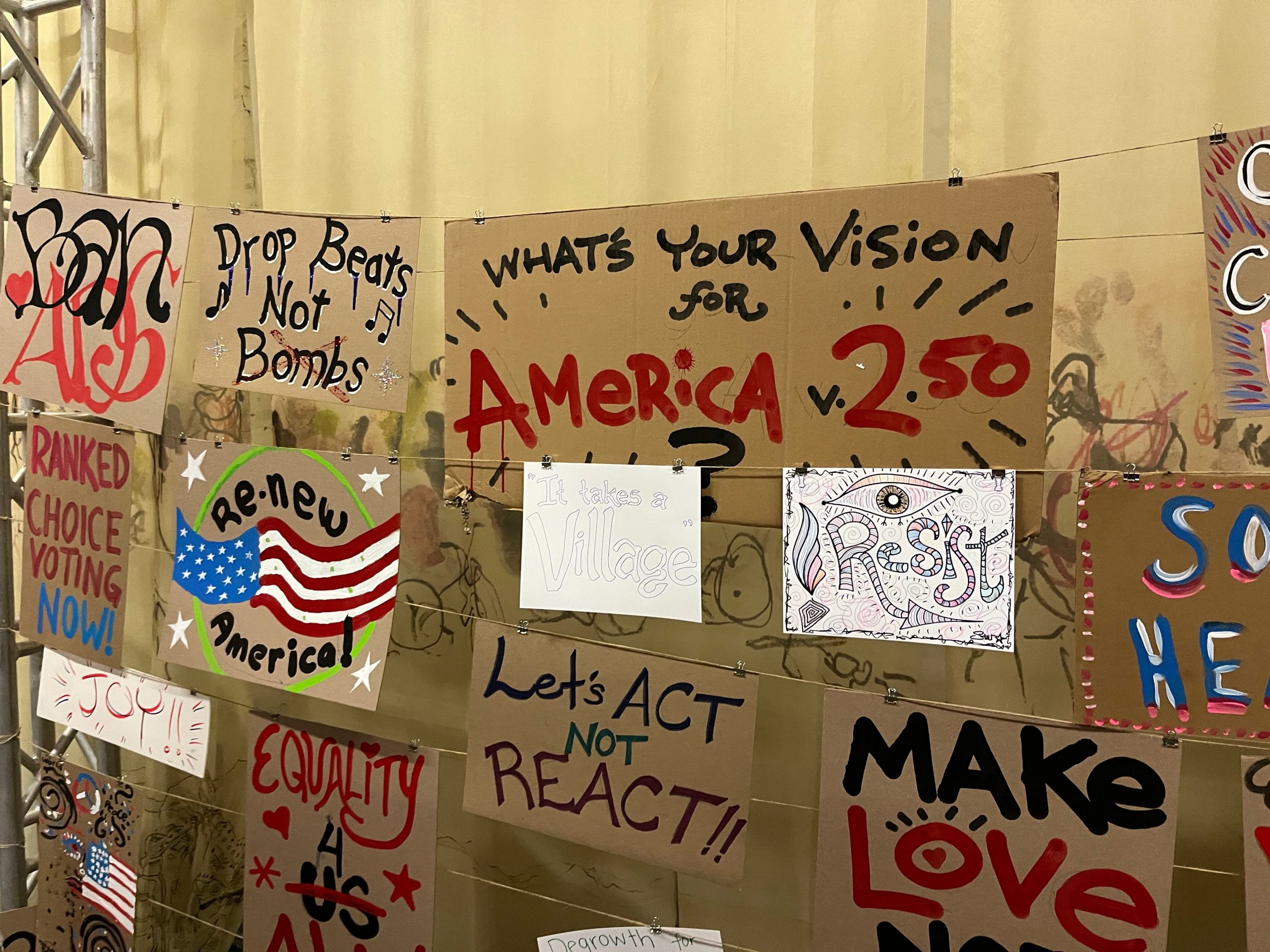 A wall of handmade posters asking what is your vision for America